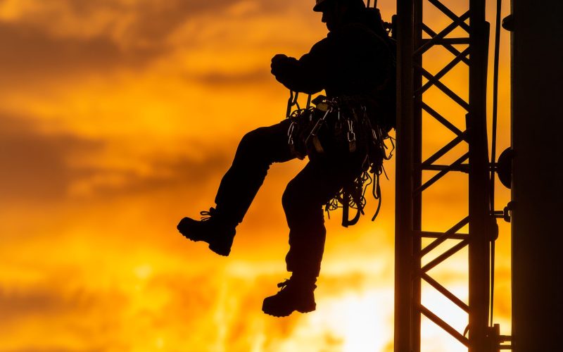 silhouette-electrician-climbing-tower-with-golden-light